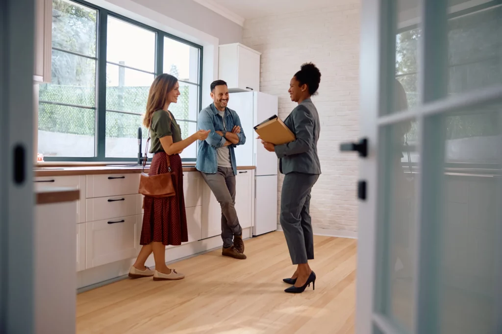 Agent immobilier présentant une cuisine à un couple pour une gestion locative à Genève