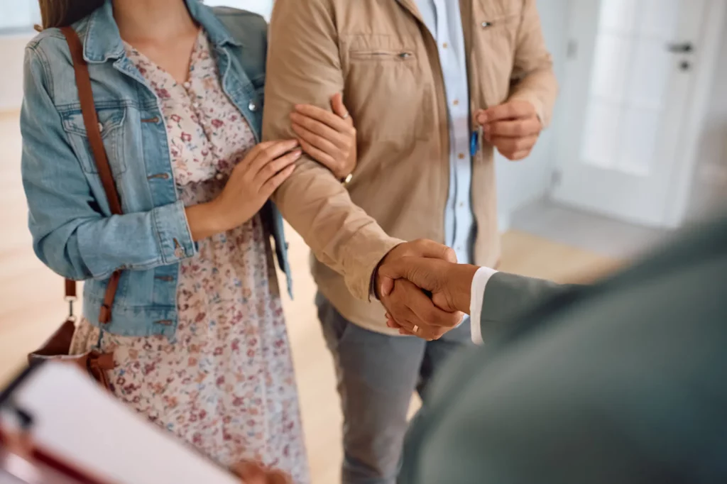 oignée de main entre un agent et un couple pour une gestion locative à Genève